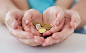 family, children, money, investments and people concept - close up of father and daughter hands holding euro money coins